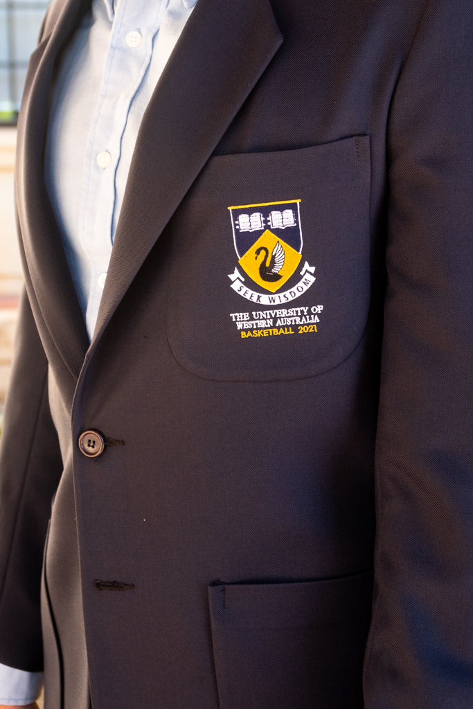 A close up of the breast of the UWA Blues Blazer. The pocket is embroided with the UWA crest. 